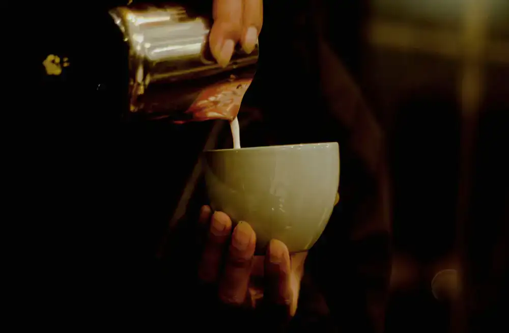 Barista pouring latte art in the urban café space